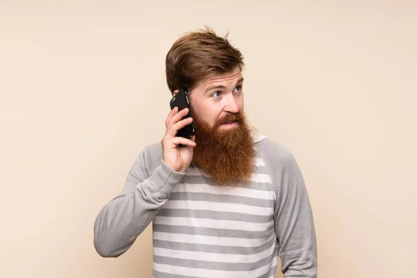 Redhead Muž Dlouhými Vousy Přes Izolované Pozadí Vedení Konverzace Mobilním — Stock fotografie