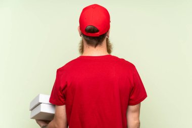 Uzun sakallı teslimatçı, yeşil arka planda izole edilmiş.