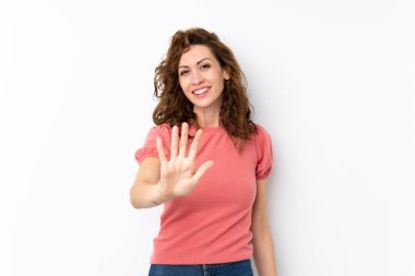 İzole edilmiş arka planda genç ve güzel bir kadın parmaklarıyla beşi sayıyor.