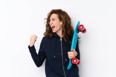 Genç ve güzel bir kadın, izole edilmiş arka planda kayıyor ve zafer jestleri yapıyor.