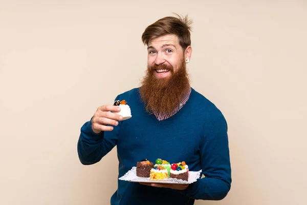 Roodharige Man Met Lange Baard Geïsoleerde Achtergrond Met Mini Cakes — Stockfoto
