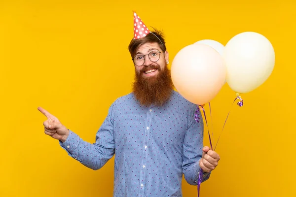Homem Ruivo Com Barba Longa Segurando Balões Sobre Fundo Amarelo — Fotografia de Stock