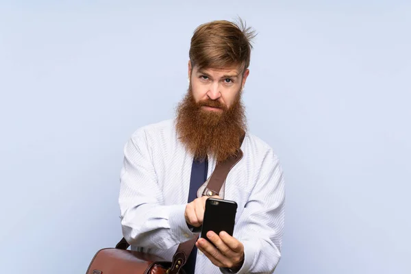 Obchodník s dlouhými vousy mluvit s mobilem přes izolované pozadí — Stock fotografie