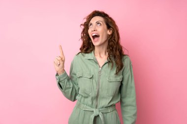 Soyutlanmış pembe arka planda genç ve güzel bir kadın var.