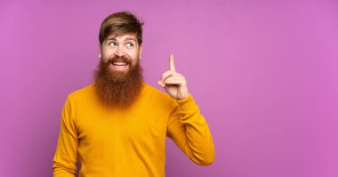 Uzun sakallı, uzun boylu, mor arkaplan sakallı bir adam. Çözümü bulmak için parmağını kaldırıyor.