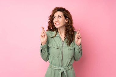 Genç ve güzel bir kadın pembe arka planda, şans diliyor ve en iyisini diliyor.