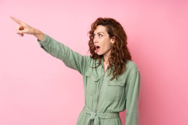 Soyutlanmış pembe arka planda genç ve güzel bir kadın.