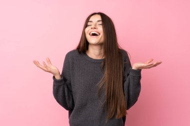 Soyutlanmış pembe arka planı olan genç bir kadın çok gülümsüyor.