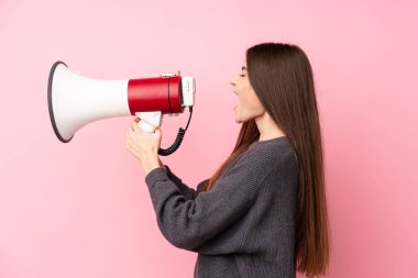 Soyutlanmış pembe arka planda genç bir kadın megafondan bağırıyor.