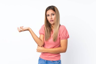 İzole edilmiş beyaz arka planı olan genç sarışın kadın bir şeyi anlamadığı için mutsuz.
