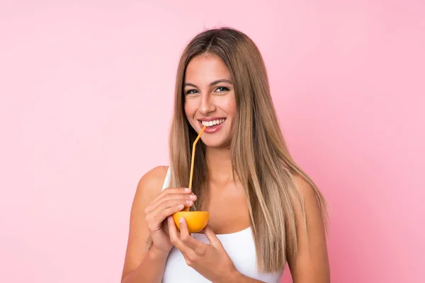 Sarışın bir kadın, izole edilmiş arka planda elinde bir portakal tutuyor. — Stok fotoğraf