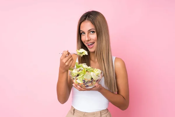 Mujer rubia joven con ensalada sobre fondo aislado — Foto de Stock