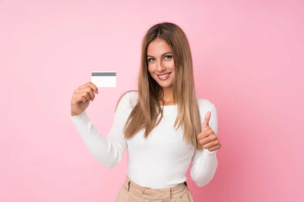 Jonge Blonde Vrouw Geïsoleerde Roze Achtergrond Met Een Creditcard — Stockfoto