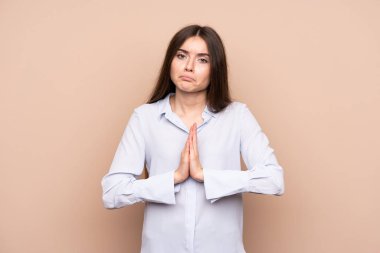 Tecrit edilmiş bir geçmişi olan genç bir kadın avuç içlerini bir arada tutar. İnsan bir şey ister.