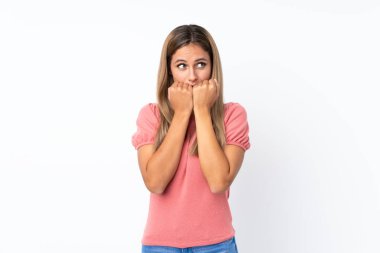 İzole edilmiş beyaz arka planda genç sarışın kadın gergin ve korkmuş.