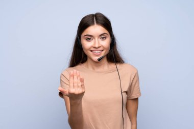 Soyutlanmış mavi bir geçmişi olan genç bir kadın kulaklıkla çalışıyor.