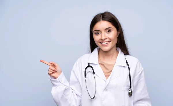 Jonge Vrouw Geïsoleerde Blauwe Achtergrond Met Arts Toga Wijzende Kant — Stockfoto