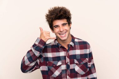 Beyaz bir adam telefon jesti yapıyor. Bana geri dönüş işareti ver.