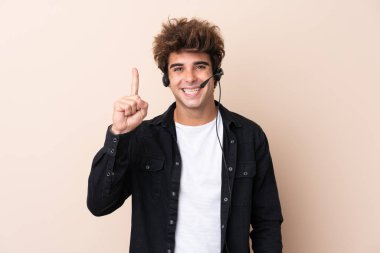 Tele pazarlamacı, izole edilmiş arka plan üzerinde çalışan ve işaret parmağıyla işaret eden bir kulaklıkla çalışmak harika bir fikir.