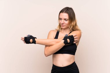 Sarışın sporcu kadın izole edilmiş arka planda gerinen kol