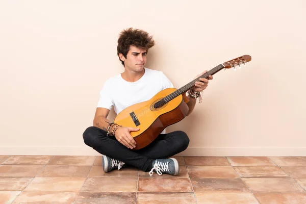 Joven Hombre Caucásico Con Una Guitarra Sentada Suelo Con Expresión — Foto de Stock