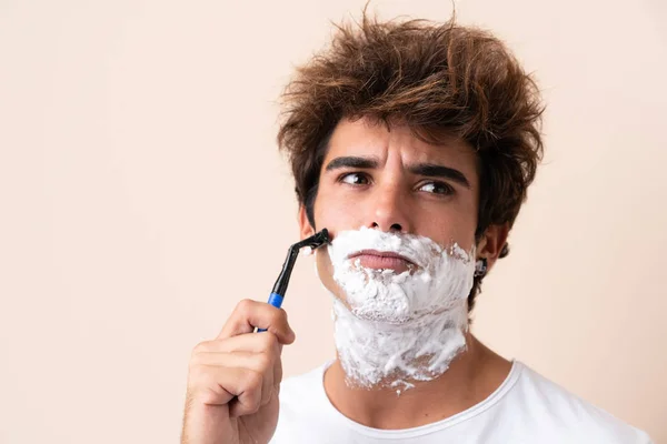 Jovem homem bonito barbeando sua barba — Fotografia de Stock