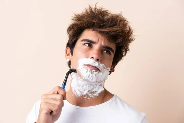 Jovem homem bonito barbeando sua barba — Fotografia de Stock