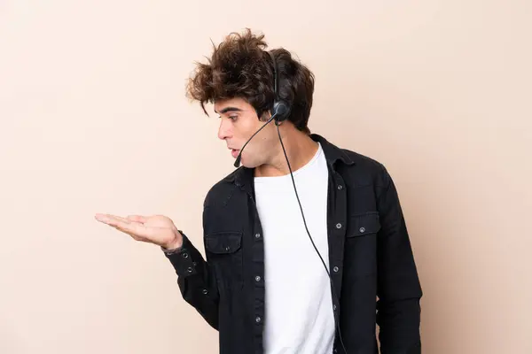 Hombre Telemarketer Trabajando Con Auricular Sobre Fondo Aislado Sosteniendo Espacio —  Fotos de Stock