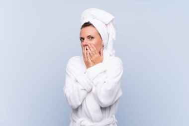 Bornozlu kadın, mavi arka planda, şaşırmış yüz ifadesi var.