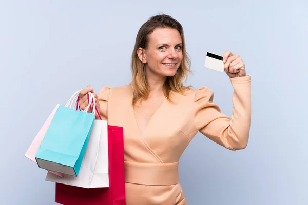 Blondýny Žena Přes Izolované Modré Pozadí Držení Nákupních Tašek Kreditní — Stock fotografie