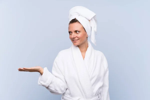 Woman Bathrobe Isolated Blue Background Holding Copyspace Imaginary Palm — 图库照片