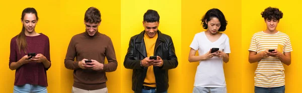 Zole Edilmiş Sarı Arkaplan Üzerinde Bir Grup Insan Cep Telefonuyla — Stok fotoğraf