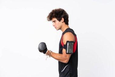 İzole edilmiş beyaz arka planda dövmeleri olan genç bir sporcu halter yapıyor.