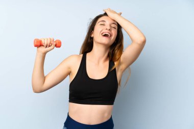 Yalıtılmış mavi arka planda ağırlık kaldıran genç bayan bir şey fark etti ve çözüme niyetlendi.