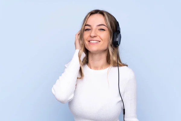 Jovem Mulher Sobre Isolado Fundo Azul Ouvir Música — Fotografia de Stock