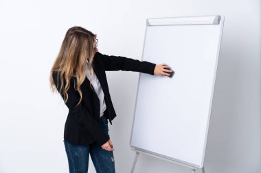 İzole edilmiş beyaz arka planda genç bir kadın beyaz tahtada sunum yapıyor.