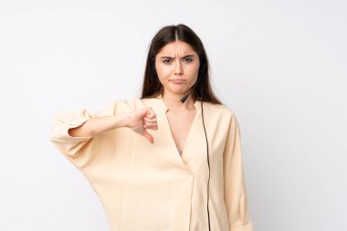 İzole edilmiş beyaz arka planda genç bir pazarlamacı kadın baş parmağını aşağı gösteriyor.