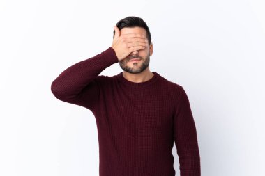 İzole edilmiş beyaz arka planda sakallı, genç ve yakışıklı bir adam. Gözlerini elleriyle kapatıyor. Bir şey görmek istemiyorum.