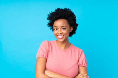 Afro-Amerikalı kadın, izole edilmiş mavi arka plan gülüyor.