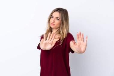 İzole edilmiş beyaz arka planda genç bir kadın gergin ellerini öne uzatıyor.