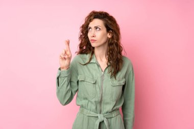 Genç ve güzel bir kadın pembe arka planda, şans diliyor ve en iyisini diliyor.