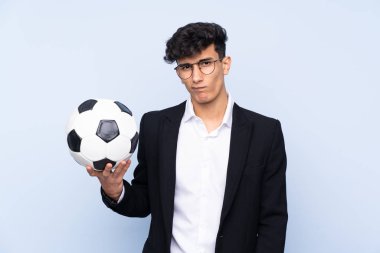 Arjantinli futbol koçu hüzünlü bir ifadeyle izole edilmiş mavi arka plan üzerinden