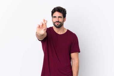 Sakallı yakışıklı genç bir adam izole beyaz bir geçmişi var. Parmakları çapraz ve en iyisini diliyor.