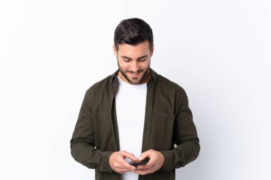 Sakallı, beyaz bir geçmişi olan genç ve yakışıklı bir adam cep telefonuyla mesaj yolluyor.