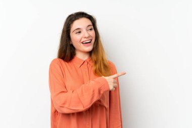 Genç esmer kız izole edilmiş beyaz arka planda şaşırmış ve işaret ediyor.