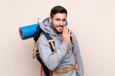 Sırtında büyük bir sırt çantasıyla izole edilmiş genç dağcı adam bir şeyler fısıldıyor.