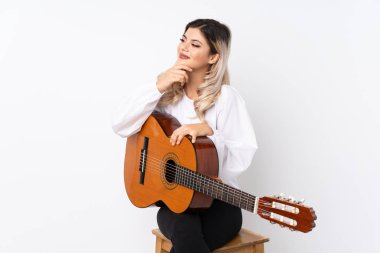 İzole edilmiş beyaz arka planda gitar çalan genç bir kız.