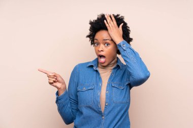 Afrika kökenli Amerikalı bir kadın şaşırmış ve parmak kaldırmış.