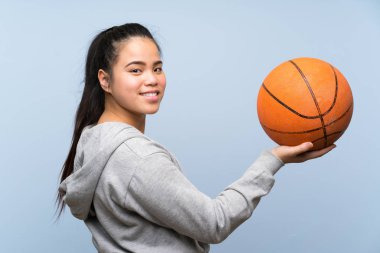 Genç Asyalı kız izole arka plan üzerinde basketbol oynuyor