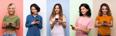 İzole edilmiş renkli arkaplan üzerindeki bir grup kadın cep telefonuyla bir mesaj gönderiyor